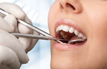 Woman Receiving Dental Checkup While in Dentist Chair