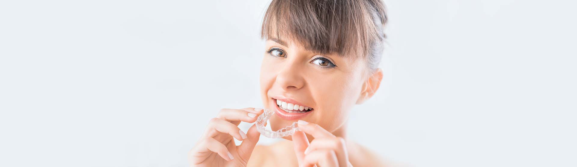Woman wearing orthodontic silicone trainer. Invisible braces aligner.