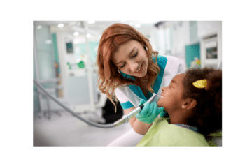 Friendly dentist examining young patient's teeth during dental checkup at Marietta practice.