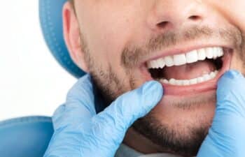 Male patient with bright white teeth smiling during dental examination in Marietta.