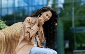Woman smiling while on phone call in modern dental office setting in Marietta, GA.
